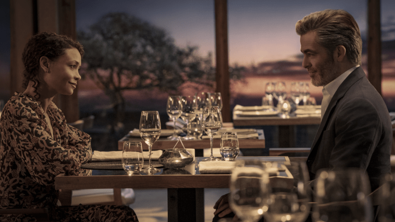 A picture of a scene of All The Old Knives, where two characters are dining together at sunset.