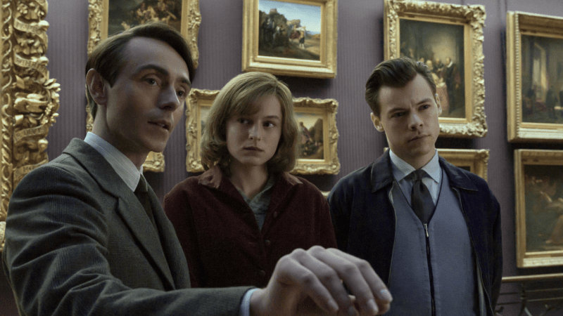 The characters of My Policeman are featured in a museum, with plenty of pictures and frames behind them.