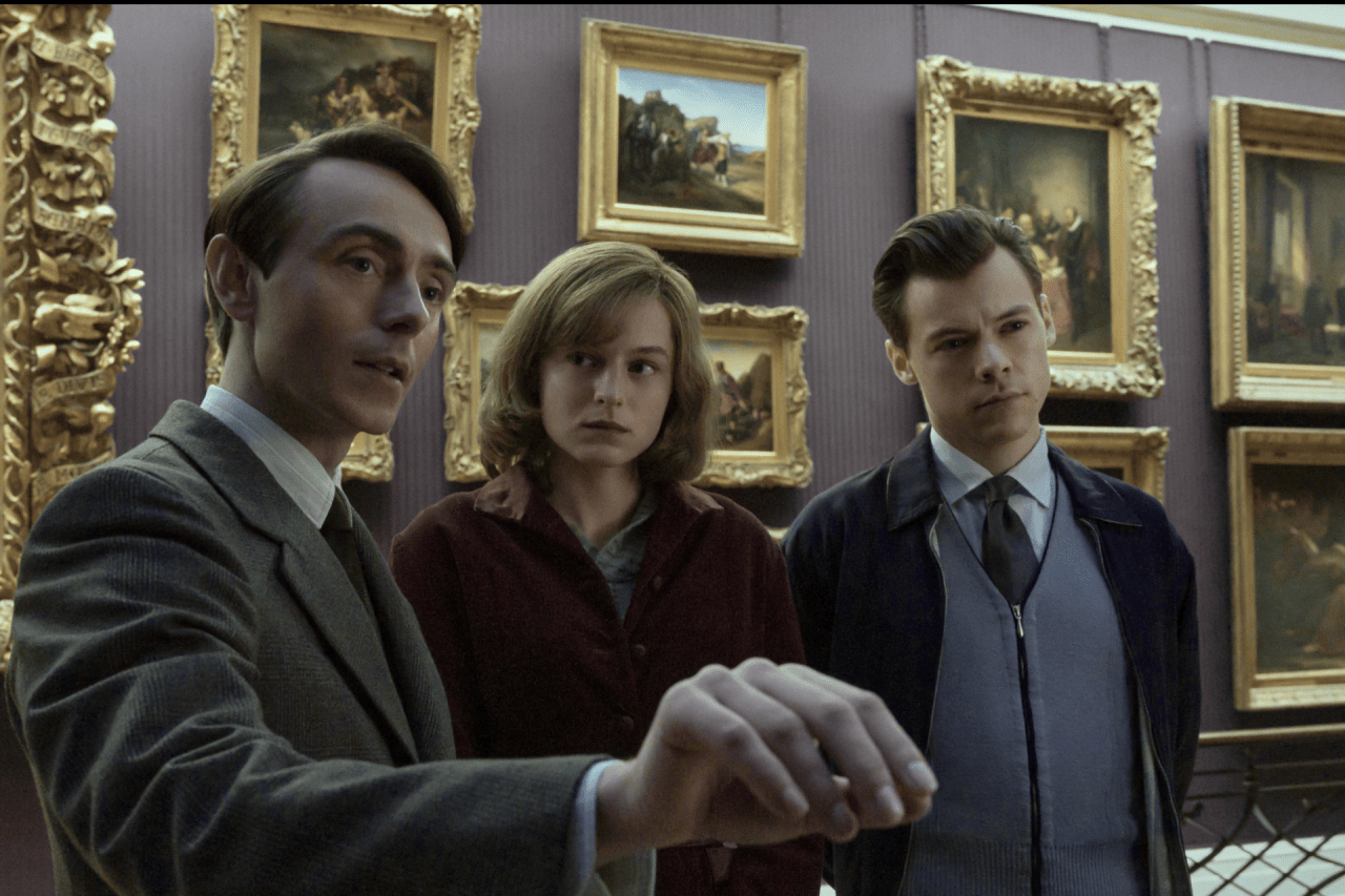 The characters of My Policeman are featured in a museum, with plenty of pictures and frames behind them.