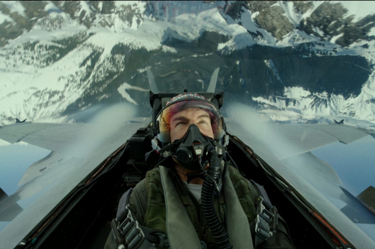 Tom Cruise is sitting in a plane during a scene of Top Gun Maverick.